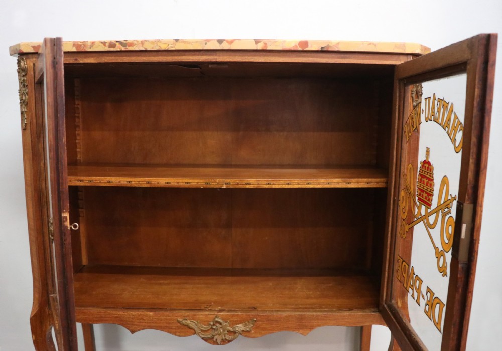 An early 20th-century French wooden display cabinet featuring a marble top, cabriole legs, gilt bronze mounts, and glass doors with hand-painted Chateauneuf-du-Pape lettering. View XXI