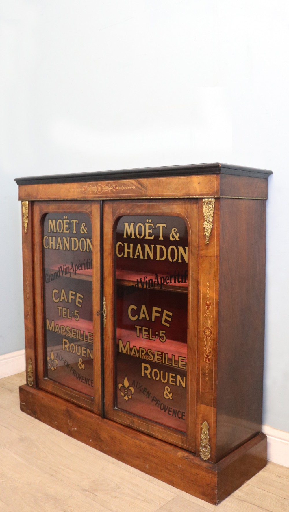 A Victorian walnut veneered and inlaid pier type display cabinet, with advertising for champagne producers Moet & Chandon. View III