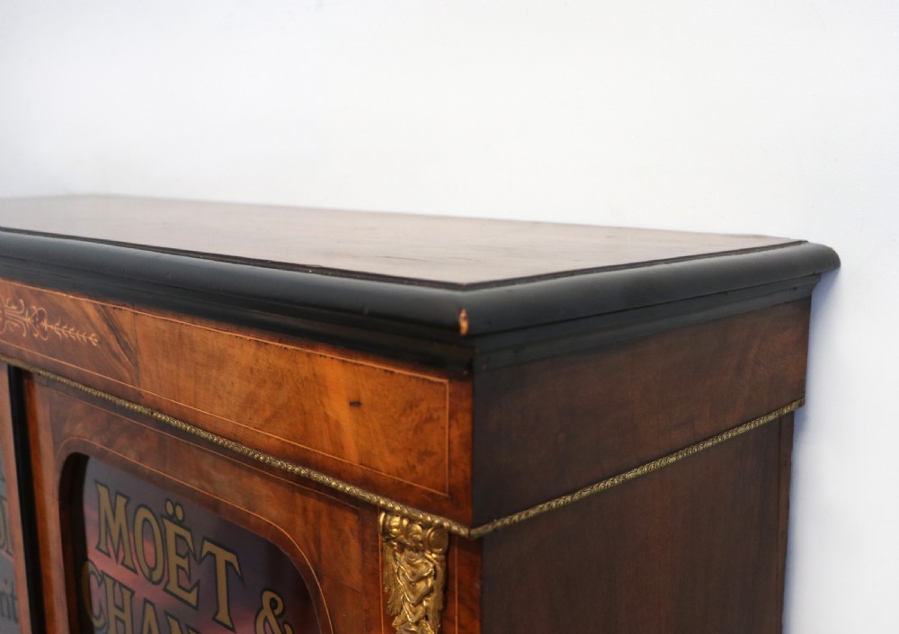 A Victorian walnut veneered and inlaid pier type display cabinet, with advertising for champagne producers Moet & Chandon. View VII
