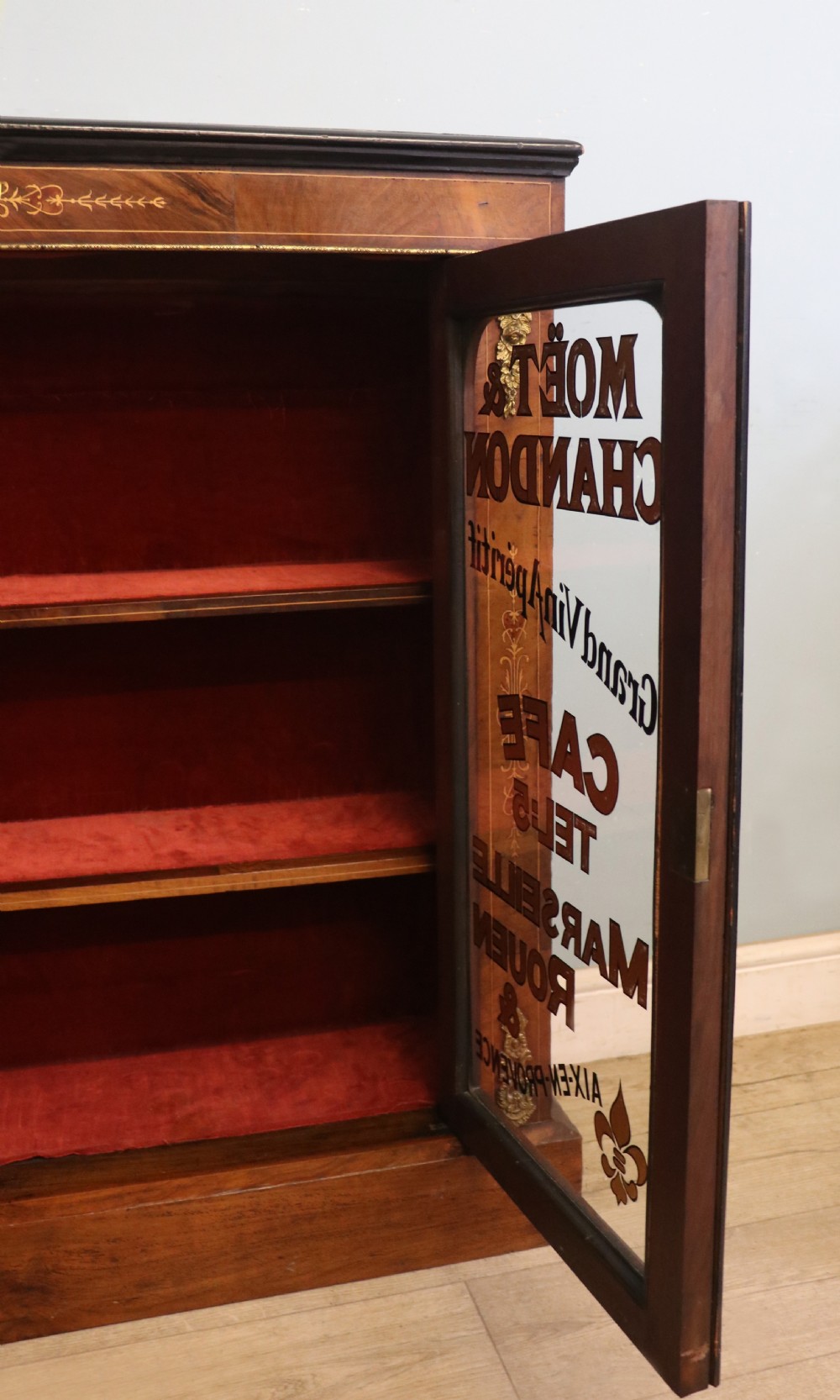 A Victorian walnut veneered and inlaid pier type display cabinet, with advertising for champagne producers Moet & Chandon. View XXI