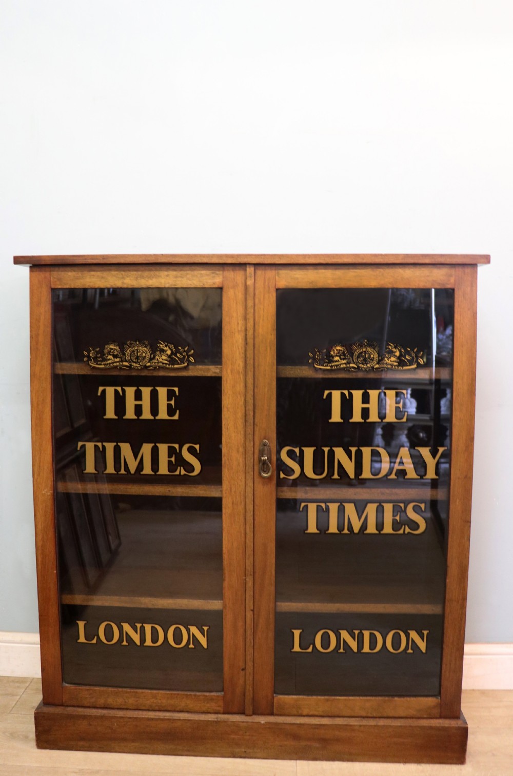 A wonderful late 19th display cabinet with sliding glass doors, later hand sign written for the Times and the Sunday Times.