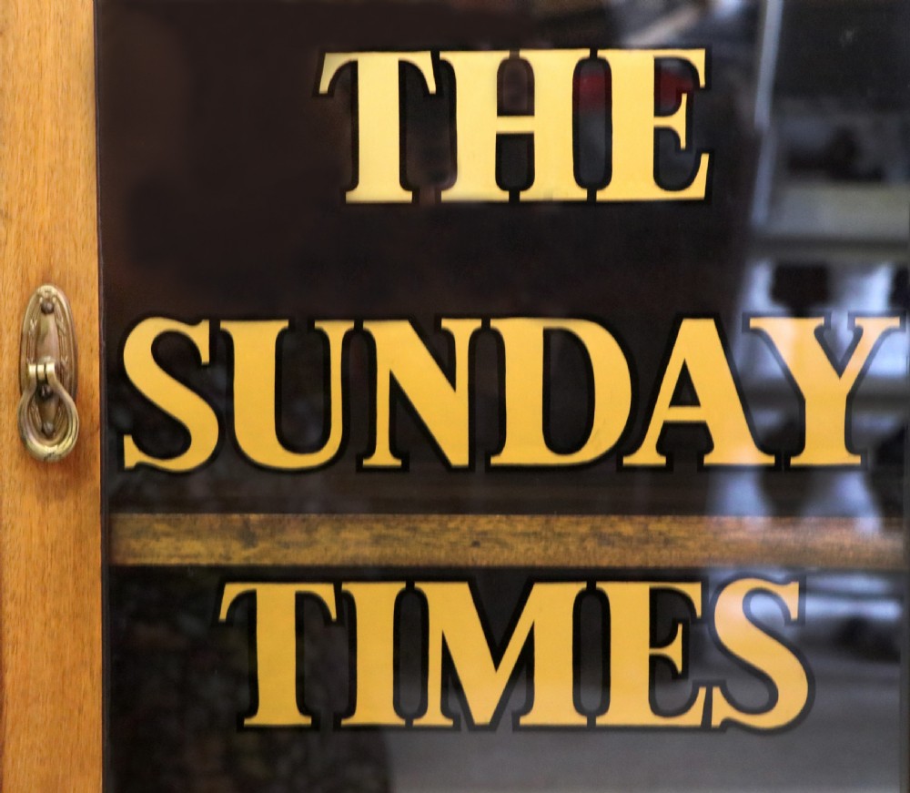 A wonderful late 19th display cabinet with sliding glass doors, later hand sign written for the Times and the Sunday Times. View VIII