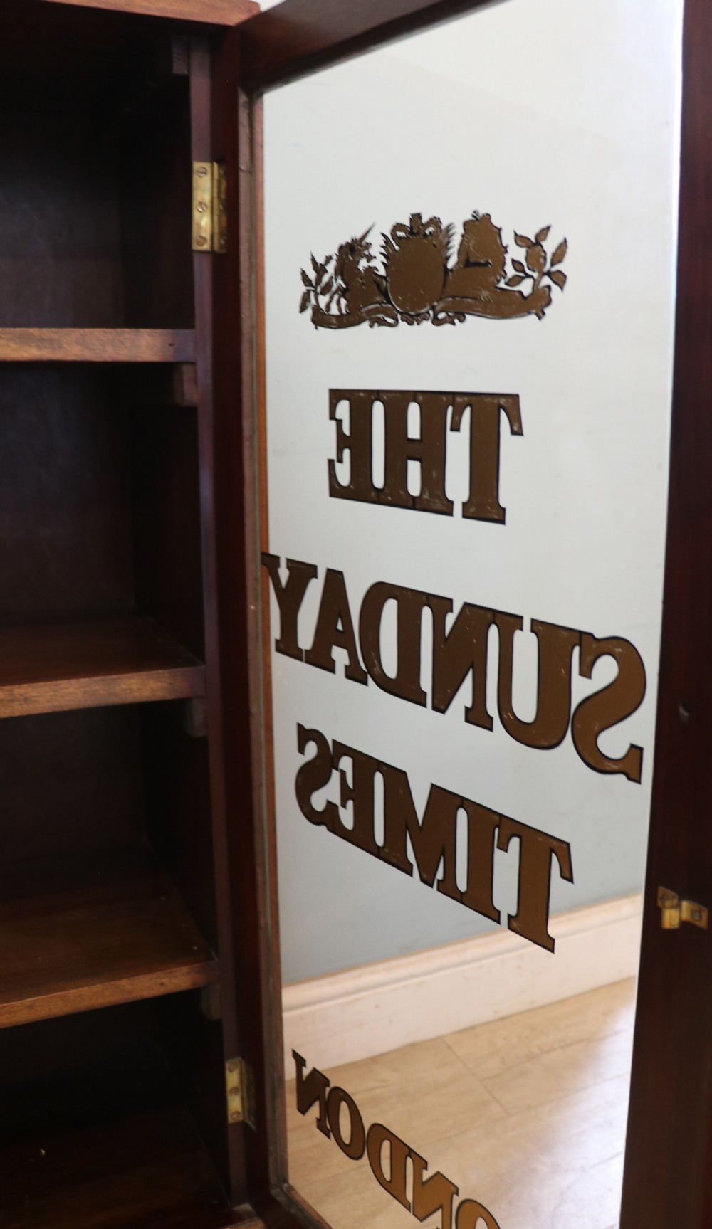 A wonderful late 19th display cabinet with sliding glass doors, later hand sign written for the Times and the Sunday Times. View XV