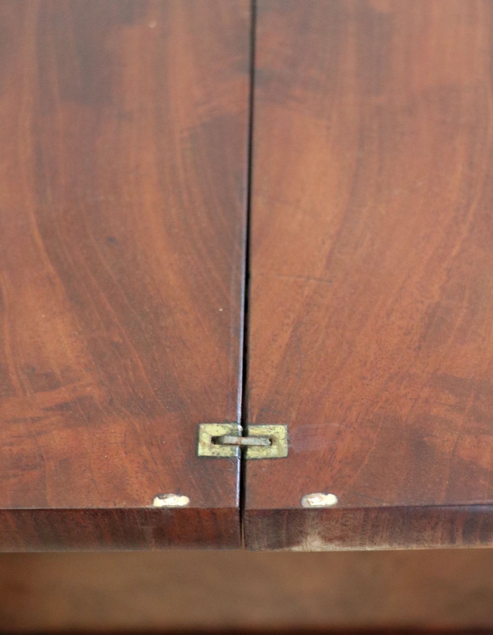 A nineteenth-century Victorian mahogany metamorphic sewing table featuring a hinged top, single drawer with brass escutcheon, tapered wooden storage bin, carved side supports, and brass castors. View XVI