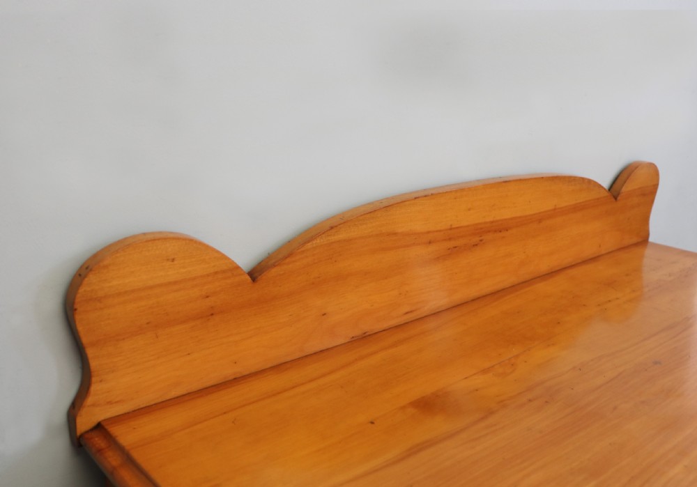 A Victorian satin birch chest of drawers featuring a shaped gallery backboard, two short over two long drawers with turned knobs, resting on a plinth base. View VIII