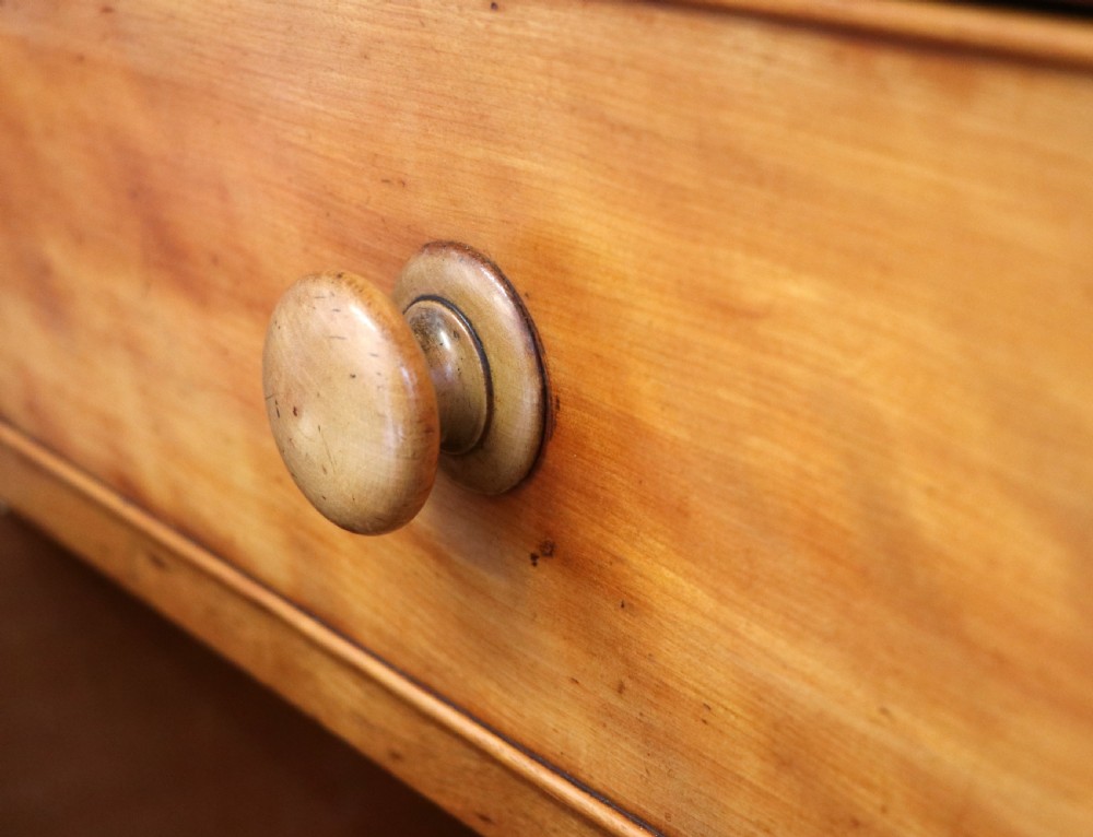 A Victorian satin birch chest of drawers featuring a shaped gallery backboard, two short over two long drawers with turned knobs, resting on a plinth base. View XIX