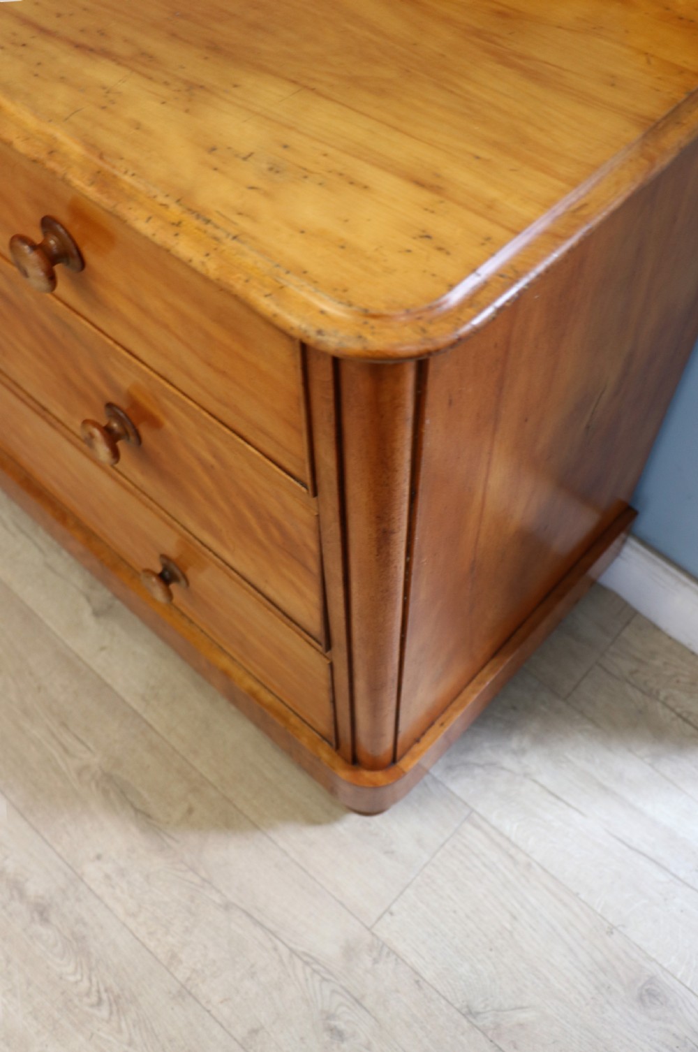 A Victorian satin birch chest of drawers featuring a shaped gallery backboard, two short over two long drawers with turned knobs, resting on a plinth base. View XX
