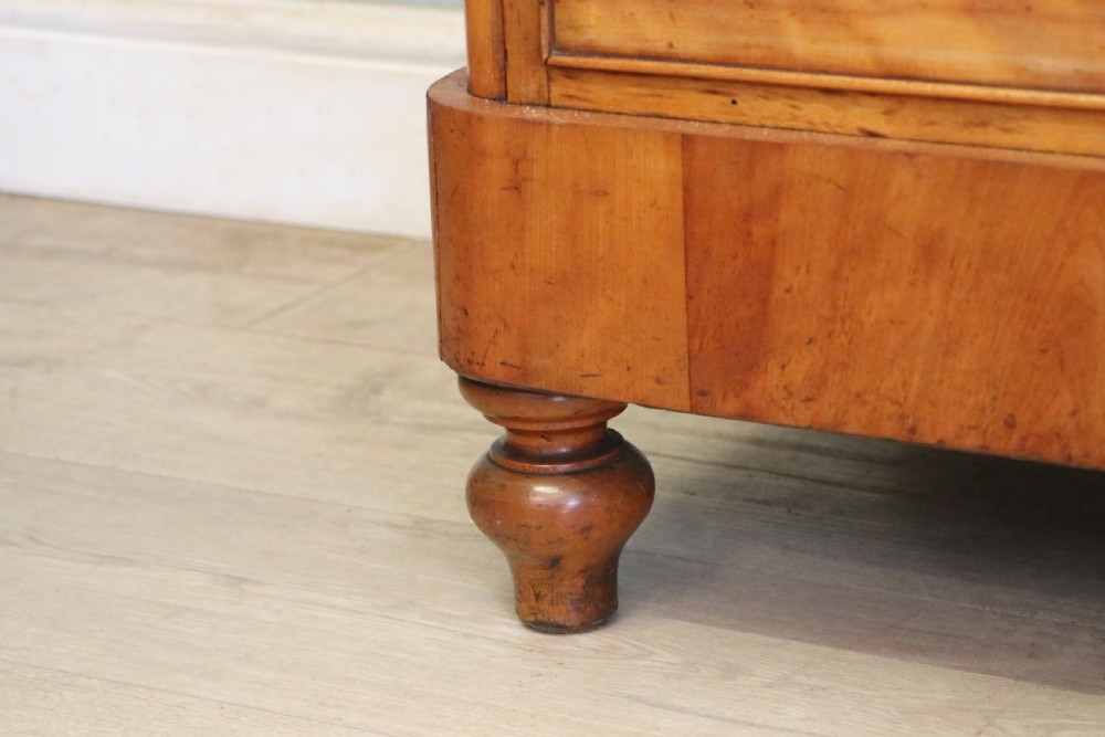 A Victorian satin birch chest of drawers featuring a shaped gallery backboard, two short over two long drawers with turned knobs, resting on a plinth base. View XXIV