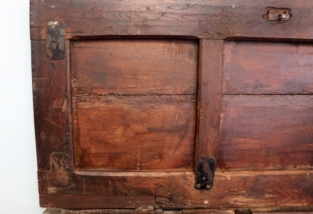 An 18th-century dark oak coffer with a hinged top lid, a carved upper frieze, and panelled lower drawers featuring brass drop handles. View XI