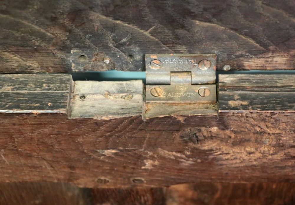 An 18th-century dark oak coffer with a hinged top lid, a carved upper frieze, and panelled lower drawers featuring brass drop handles. View XV
