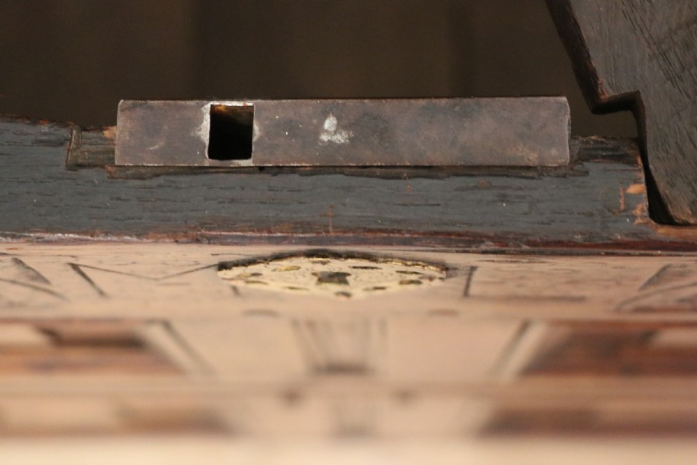 An 18th-century dark oak coffer with a hinged top lid, a carved upper frieze, and panelled lower drawers featuring brass drop handles. View XXIV