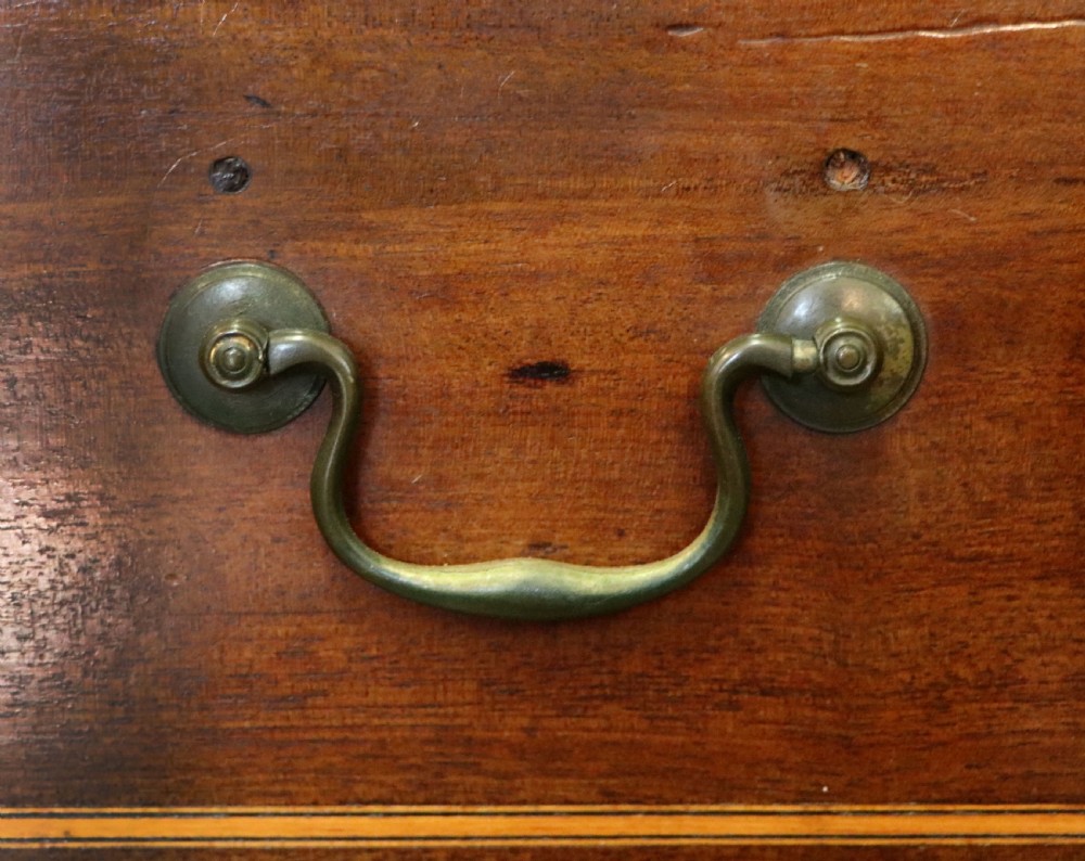 A Georgian Revival mahogany chest of drawers featuring two short drawers over three long drawers with decorative inlay and brass handles. View XIII