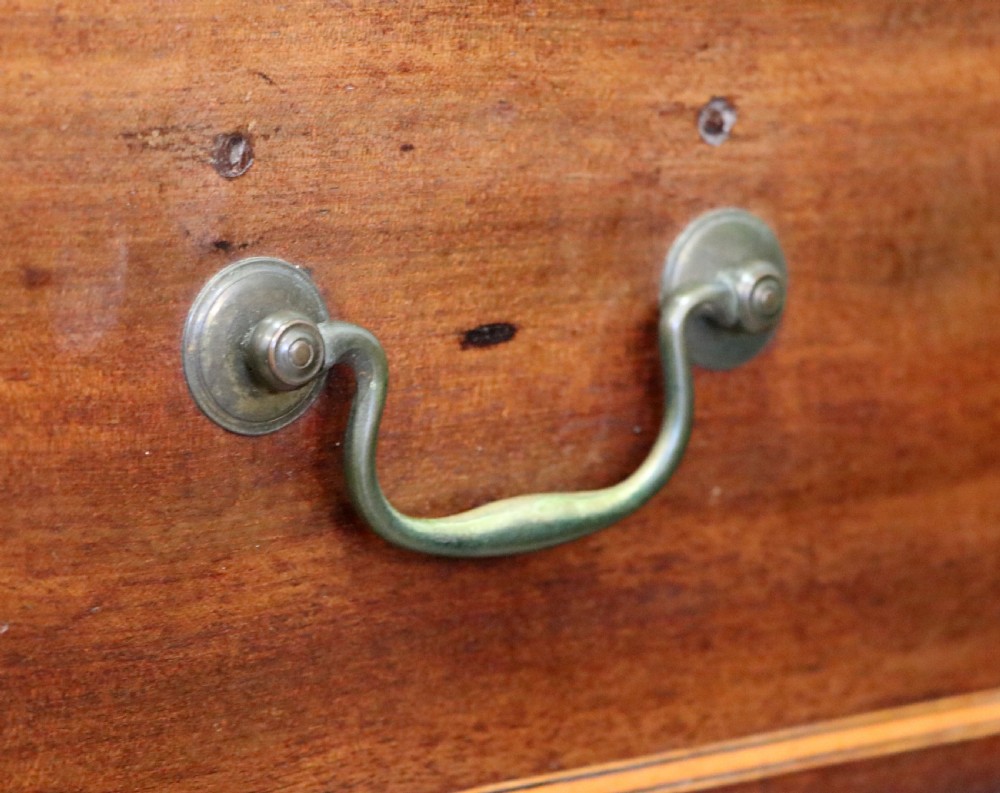 A Georgian Revival mahogany chest of drawers featuring two short drawers over three long drawers with decorative inlay and brass handles. View XV