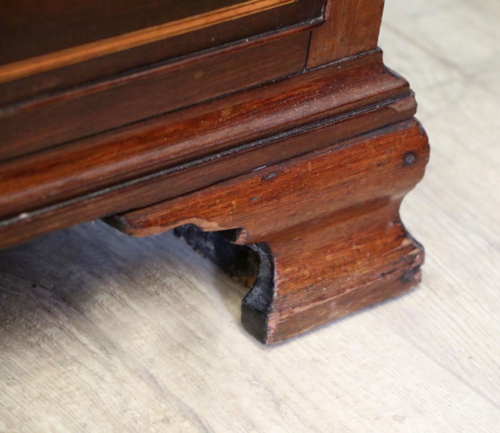 A Georgian Revival mahogany chest of drawers featuring two short drawers over three long drawers with decorative inlay and brass handles. View XVII
