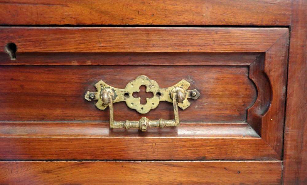 A late Victorian mahogany two-piece bookcase cabinet featuring upper glazed doors with gilded advertising lettering above two frieze drawers and a cupboard base. View XVI