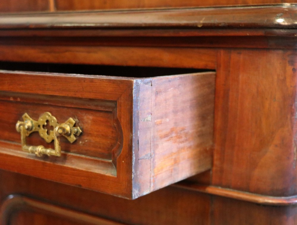 A late Victorian mahogany two-piece bookcase cabinet featuring upper glazed doors with gilded advertising lettering above two frieze drawers and a cupboard base. View XVIII