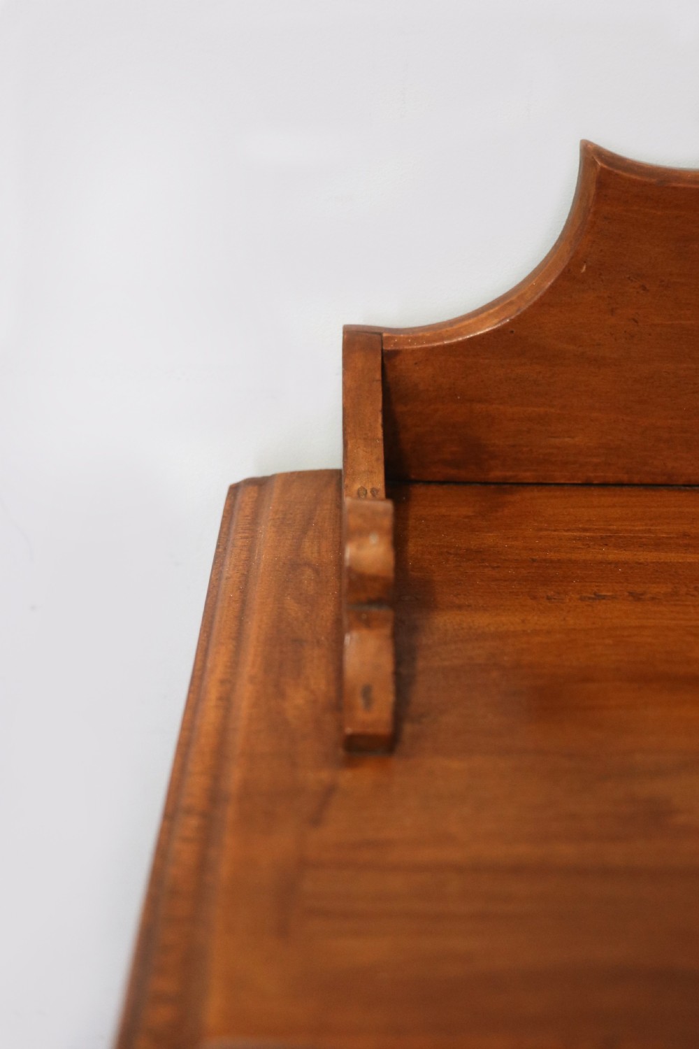 A Victorian American walnut glazed display cabinet featuring a shaped top pediment and hand-painted Frys Chocolate advertising on the single glass door. View VI