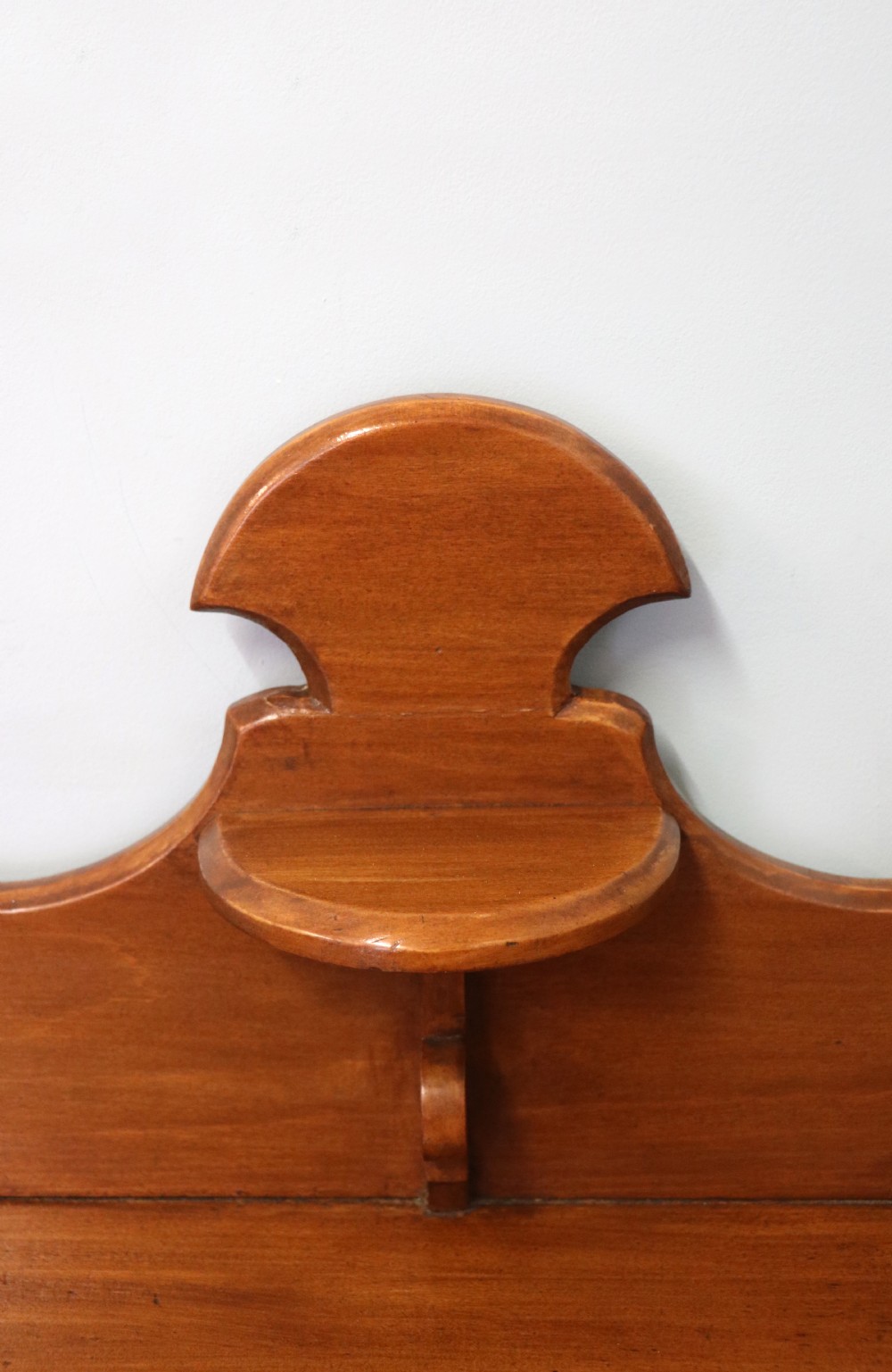 A Victorian American walnut glazed display cabinet featuring a shaped top pediment and hand-painted Frys Chocolate advertising on the single glass door. View VIII