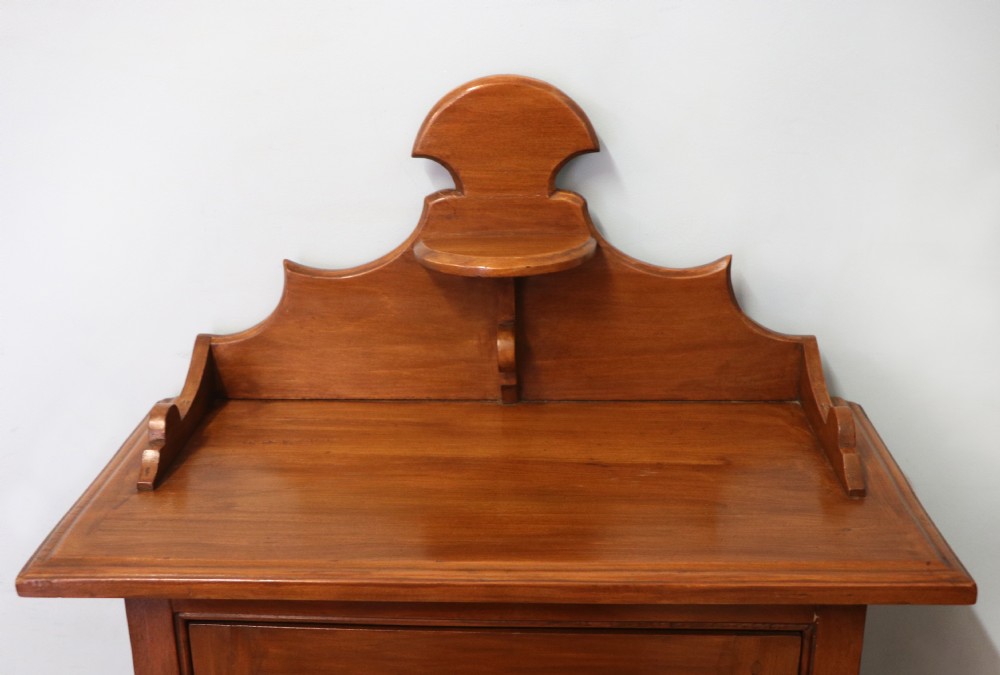 A Victorian American walnut glazed display cabinet featuring a shaped top pediment and hand-painted Frys Chocolate advertising on the single glass door. View IX