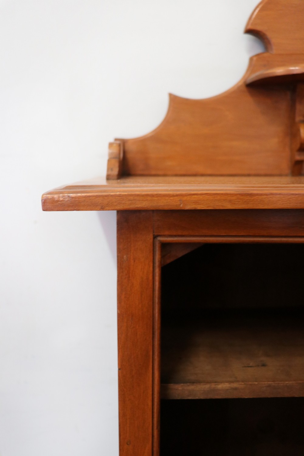 A Victorian American walnut glazed display cabinet featuring a shaped top pediment and hand-painted Frys Chocolate advertising on the single glass door. View XVII