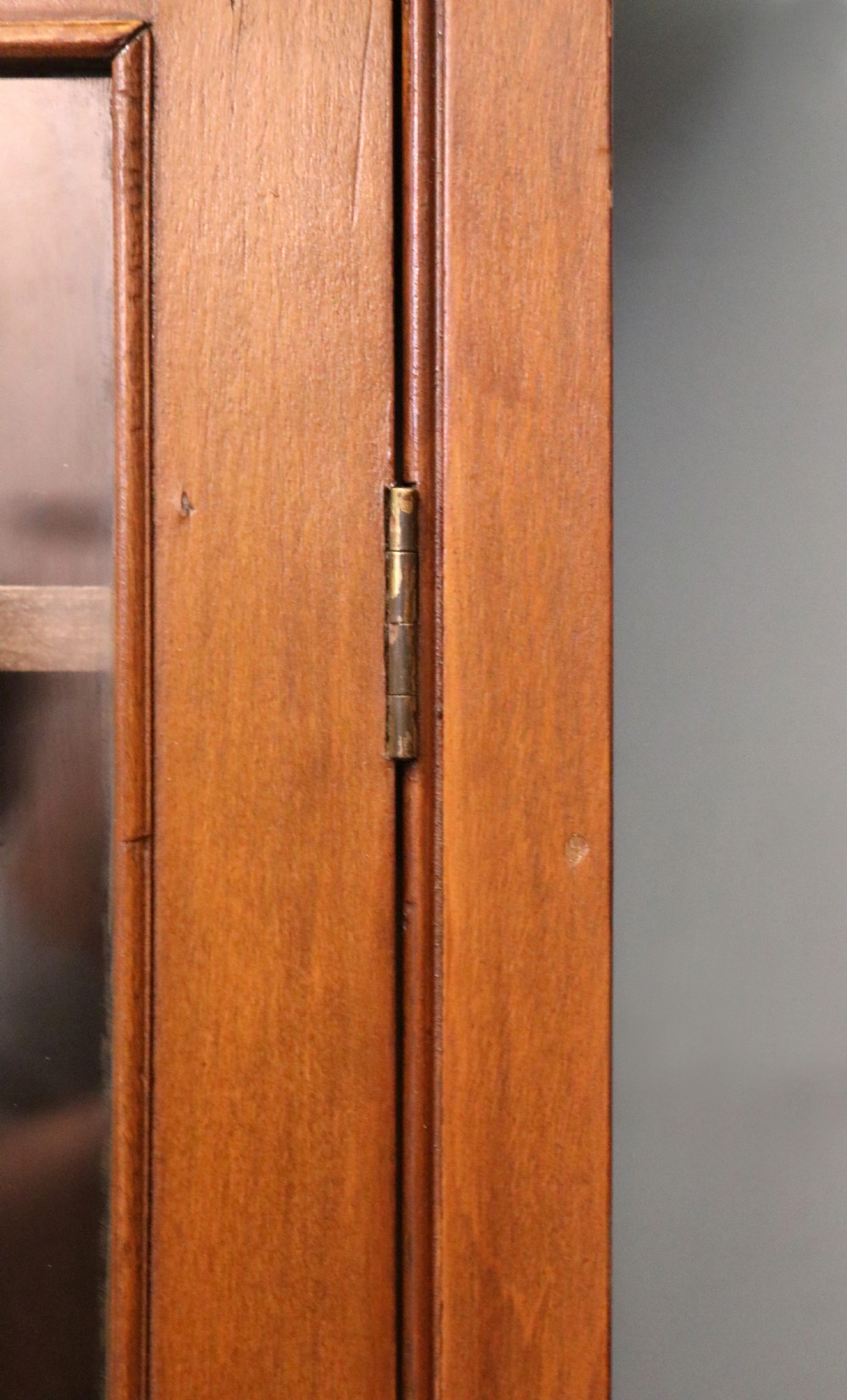 A Victorian American walnut glazed display cabinet featuring a shaped top pediment and hand-painted Frys Chocolate advertising on the single glass door. View XIX