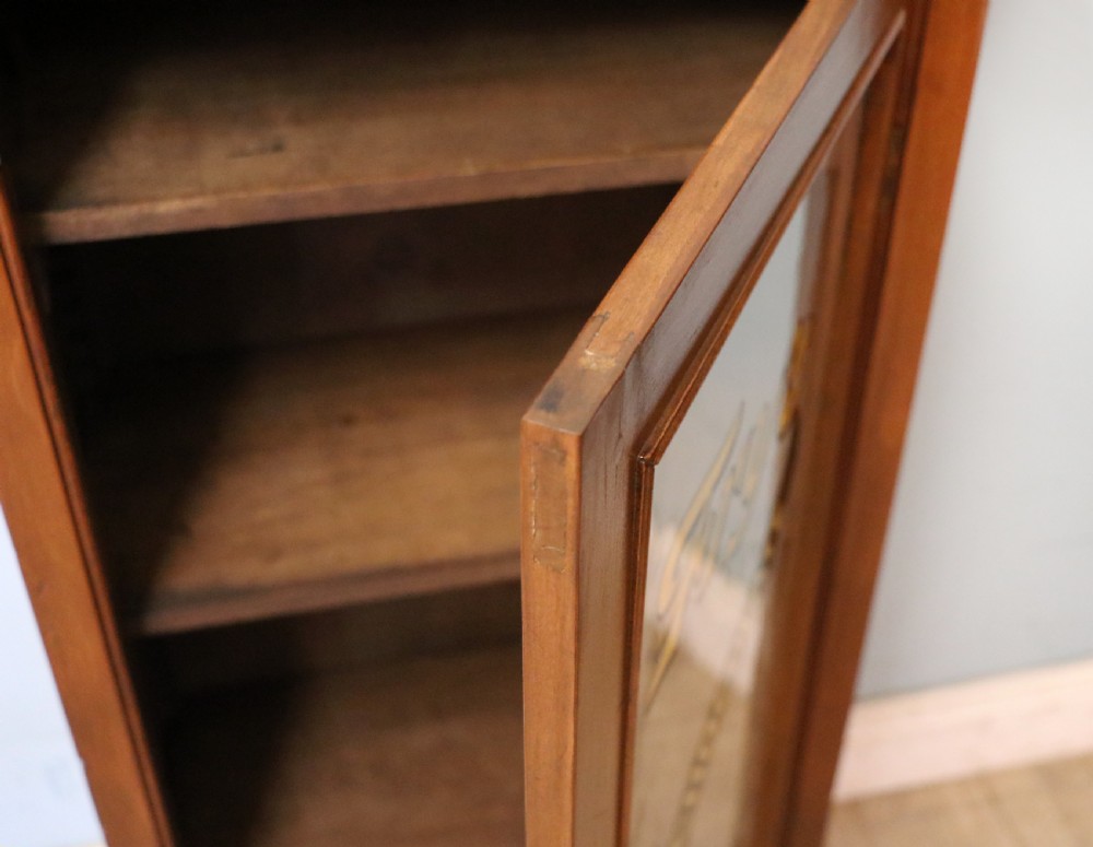 A Victorian American walnut glazed display cabinet featuring a shaped top pediment and hand-painted Frys Chocolate advertising on the single glass door. View XX