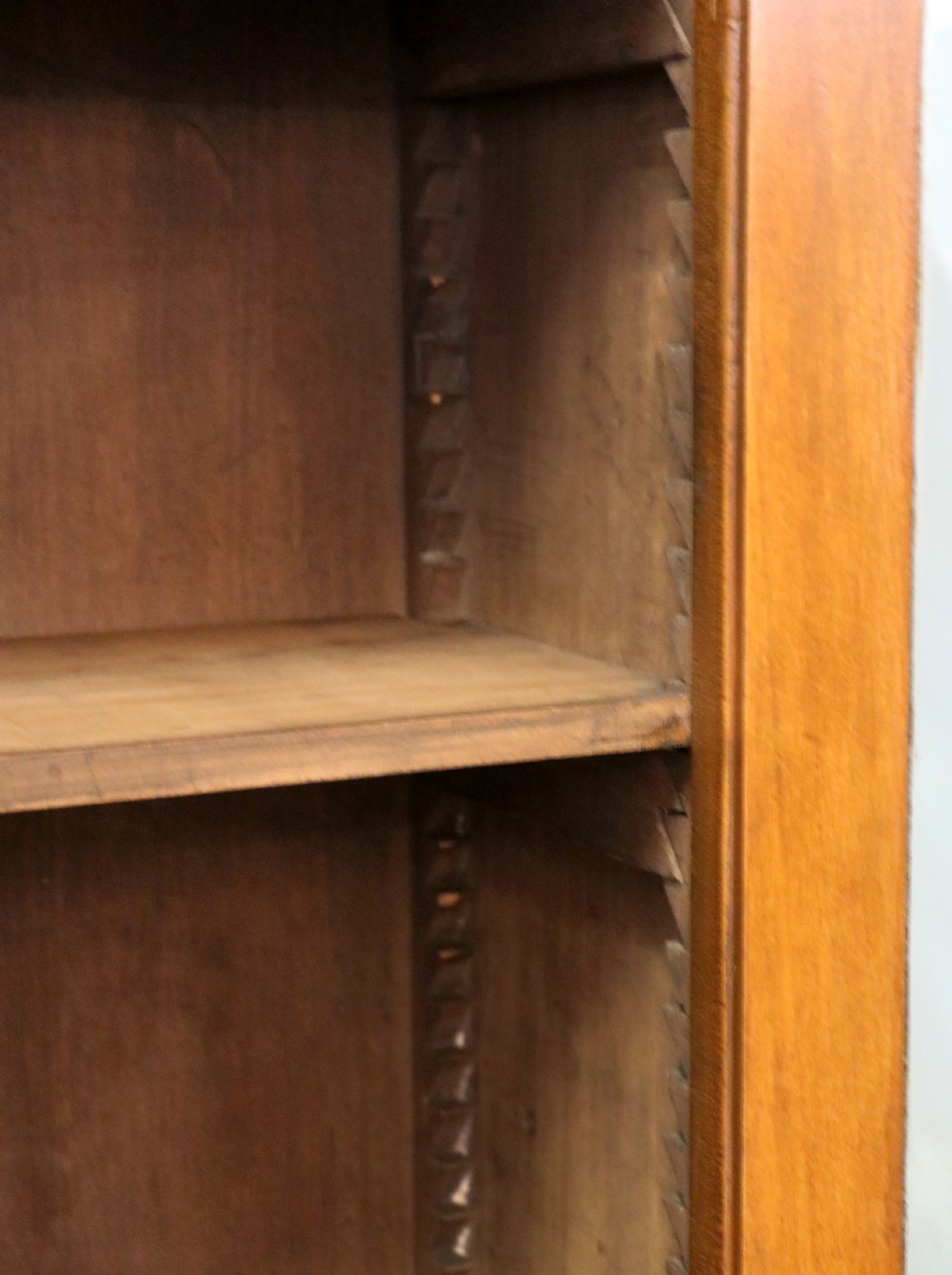 A Victorian American walnut glazed display cabinet featuring a shaped top pediment and hand-painted Frys Chocolate advertising on the single glass door. View XXI