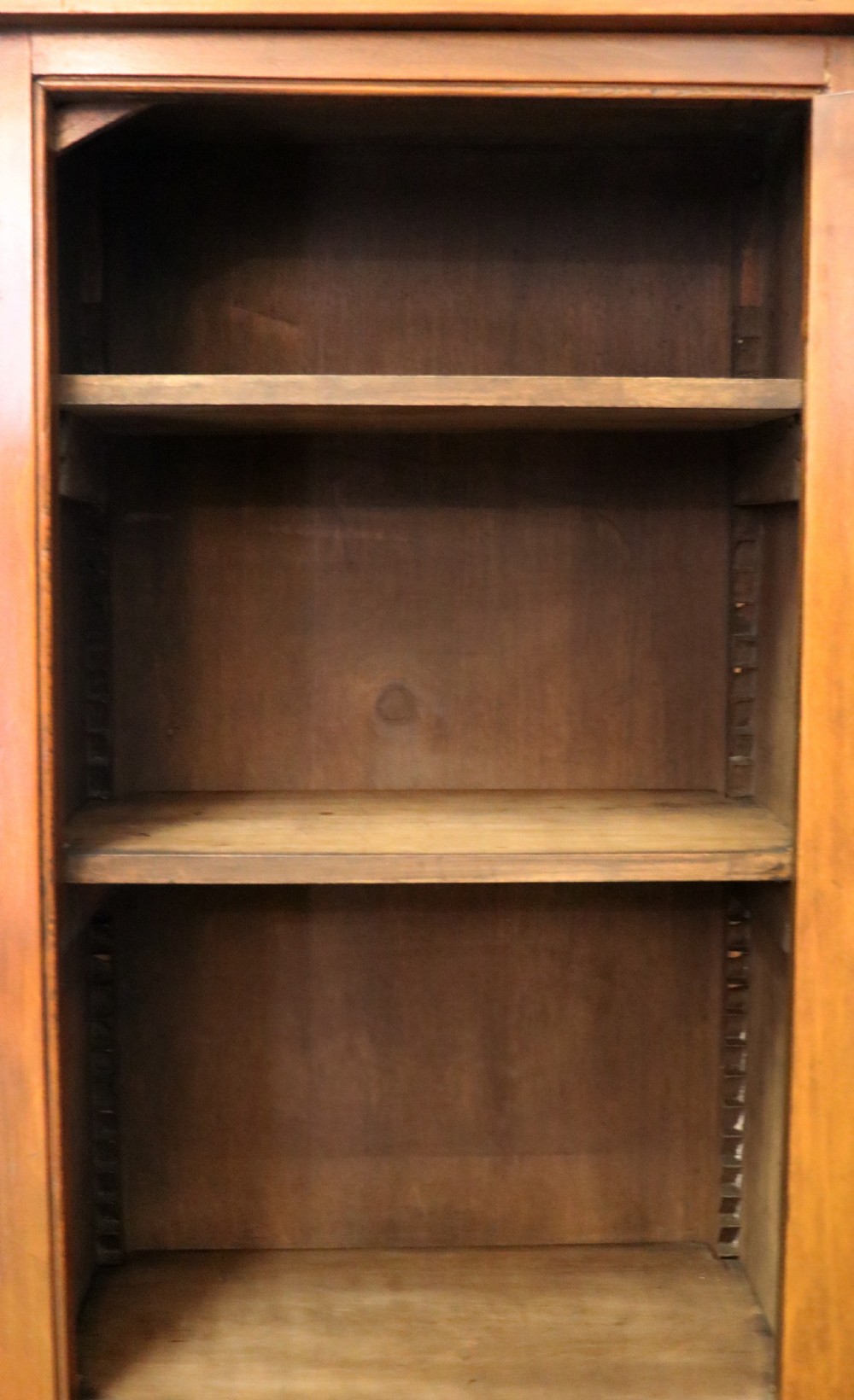 A Victorian American walnut glazed display cabinet featuring a shaped top pediment and hand-painted Frys Chocolate advertising on the single glass door. View XXII