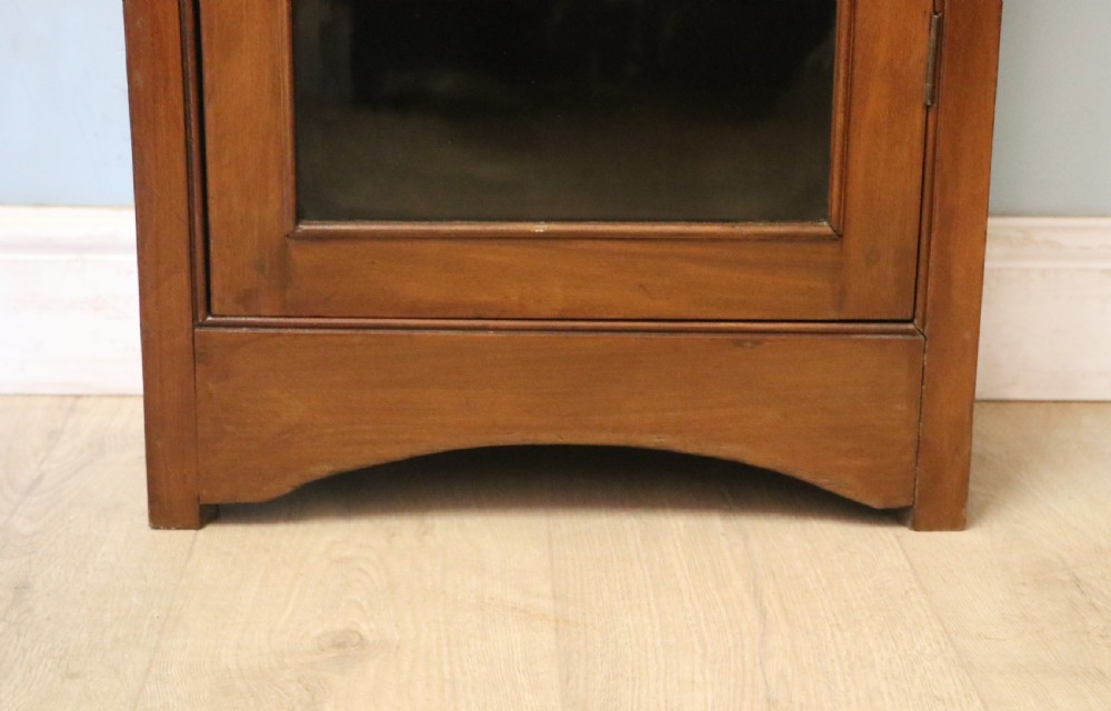 A Victorian American walnut glazed display cabinet featuring a shaped top pediment and hand-painted Frys Chocolate advertising on the single glass door. View XXIII