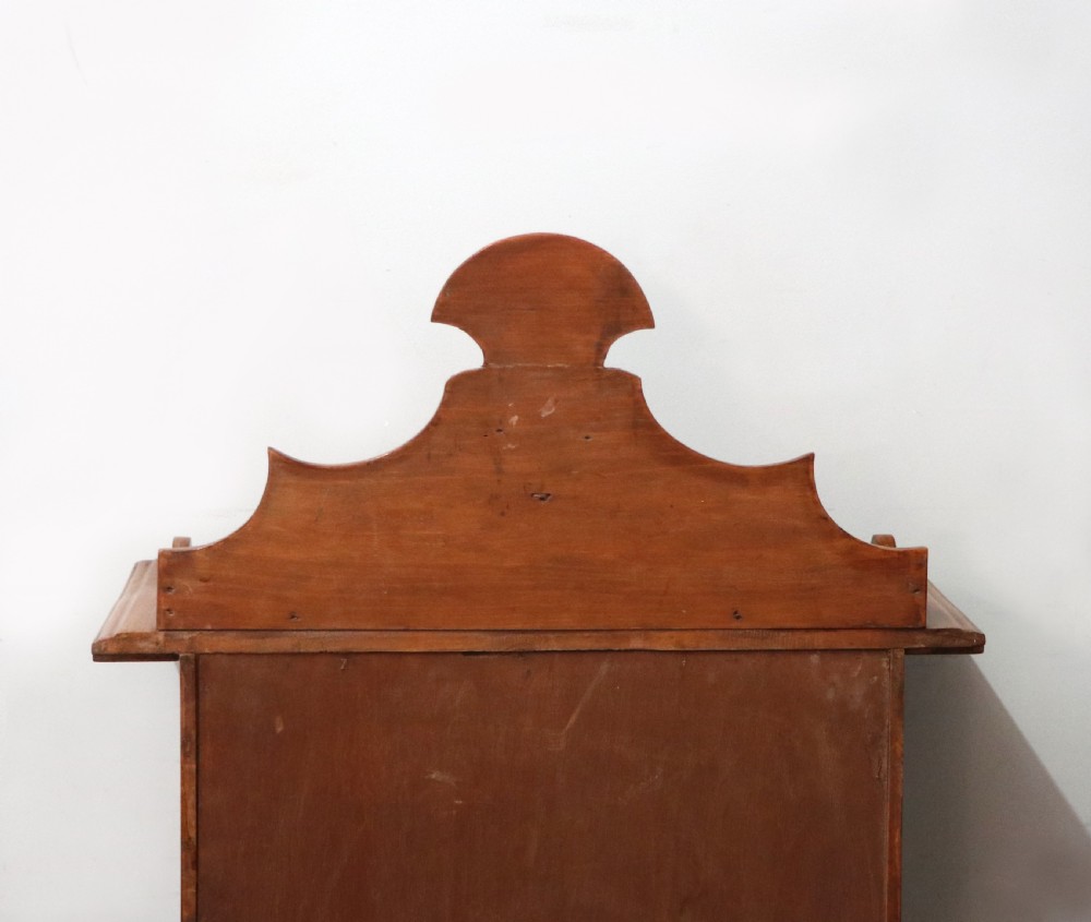 A Victorian American walnut glazed display cabinet featuring a shaped top pediment and hand-painted Frys Chocolate advertising on the single glass door. View XXVI