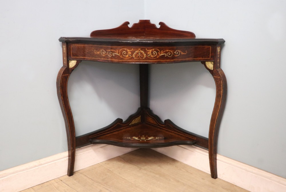 An early twentieth-century Sheraton Revival mahogany corner table featuring elaborate floral marquetry inlay, curved legs, and an undertier shelf. View II
