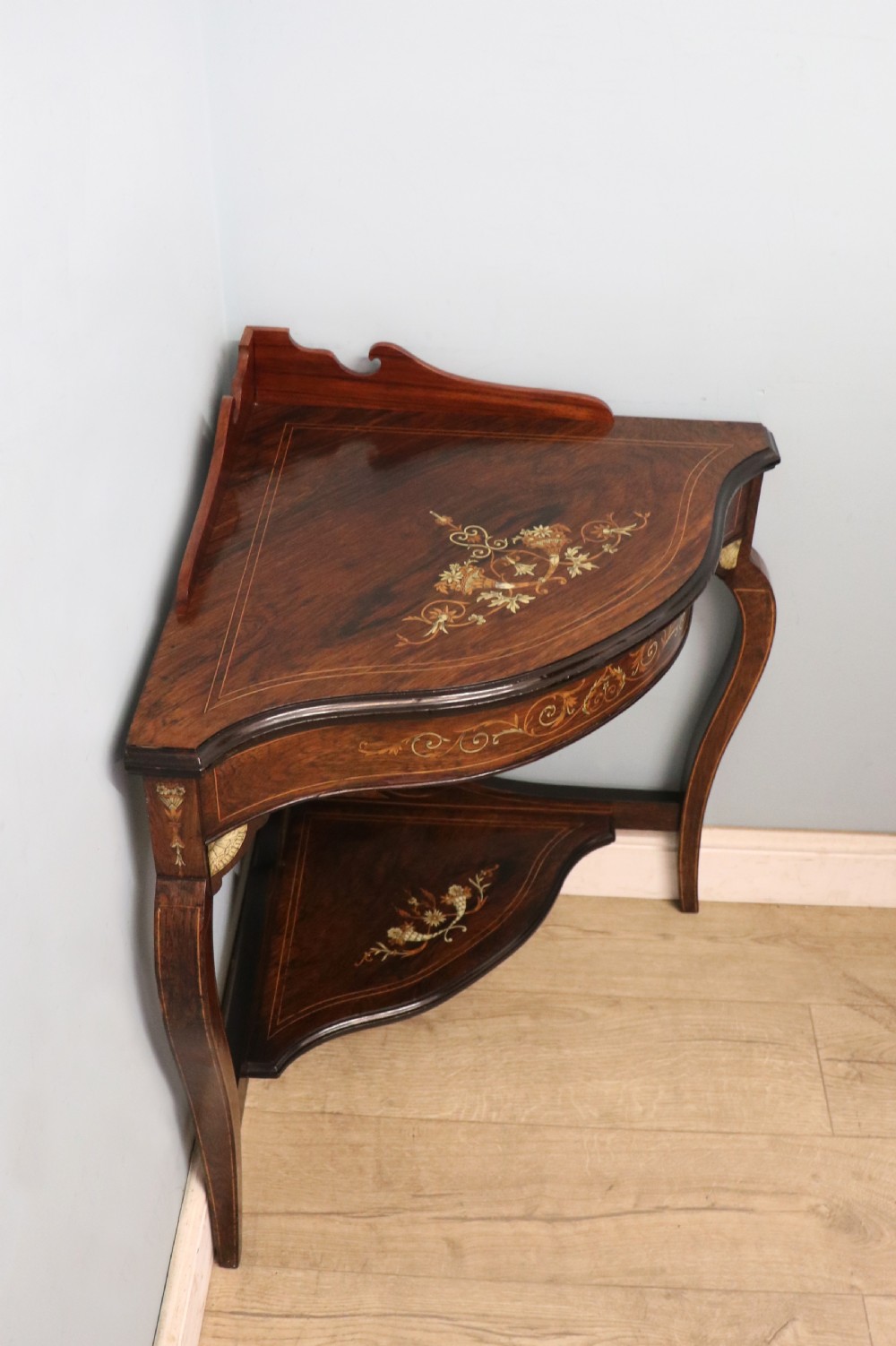 An early twentieth-century Sheraton Revival mahogany corner table featuring elaborate floral marquetry inlay, curved legs, and an undertier shelf. View IV