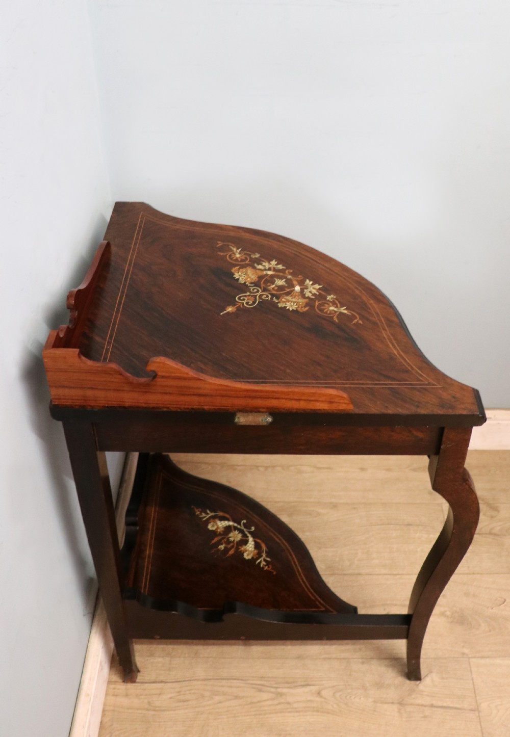 An early twentieth-century Sheraton Revival mahogany corner table featuring elaborate floral marquetry inlay, curved legs, and an undertier shelf. View VI