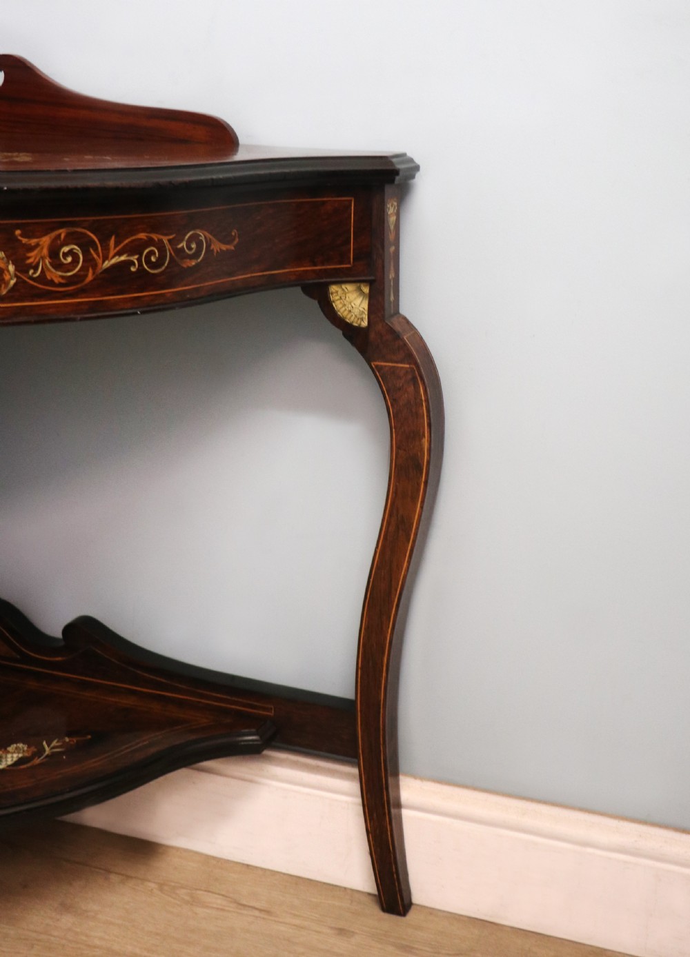 An early twentieth-century Sheraton Revival mahogany corner table featuring elaborate floral marquetry inlay, curved legs, and an undertier shelf. View XVII