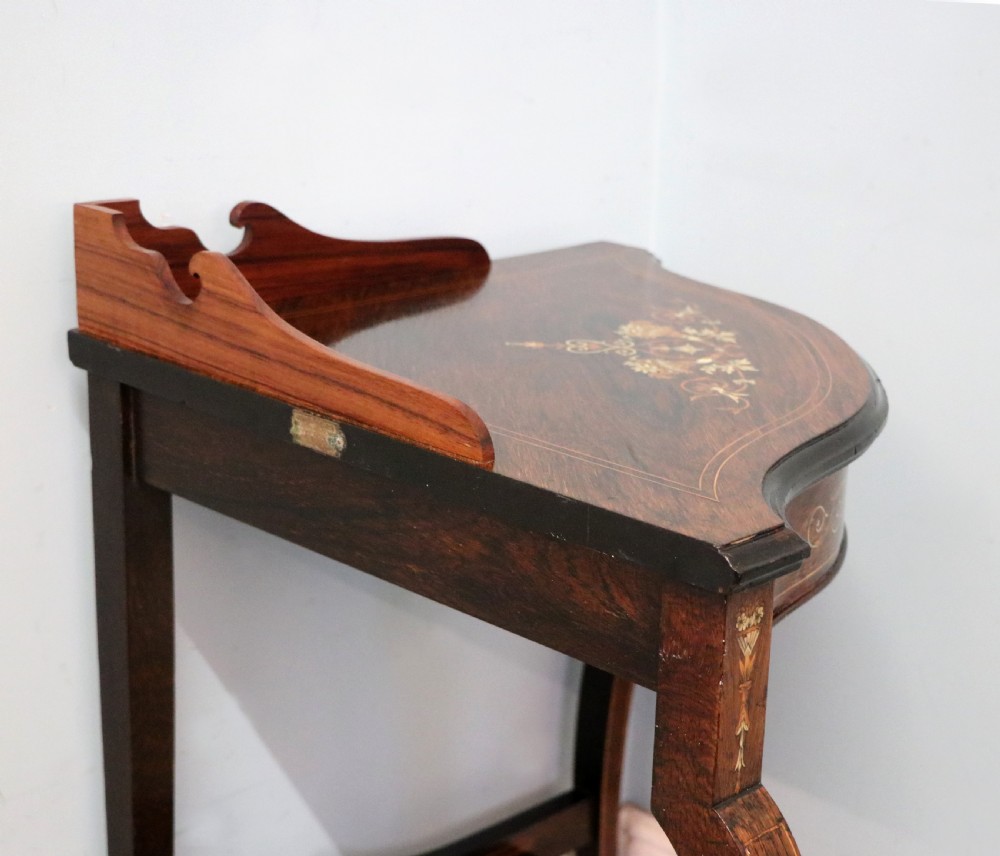 An early twentieth-century Sheraton Revival mahogany corner table featuring elaborate floral marquetry inlay, curved legs, and an undertier shelf. View XVIII