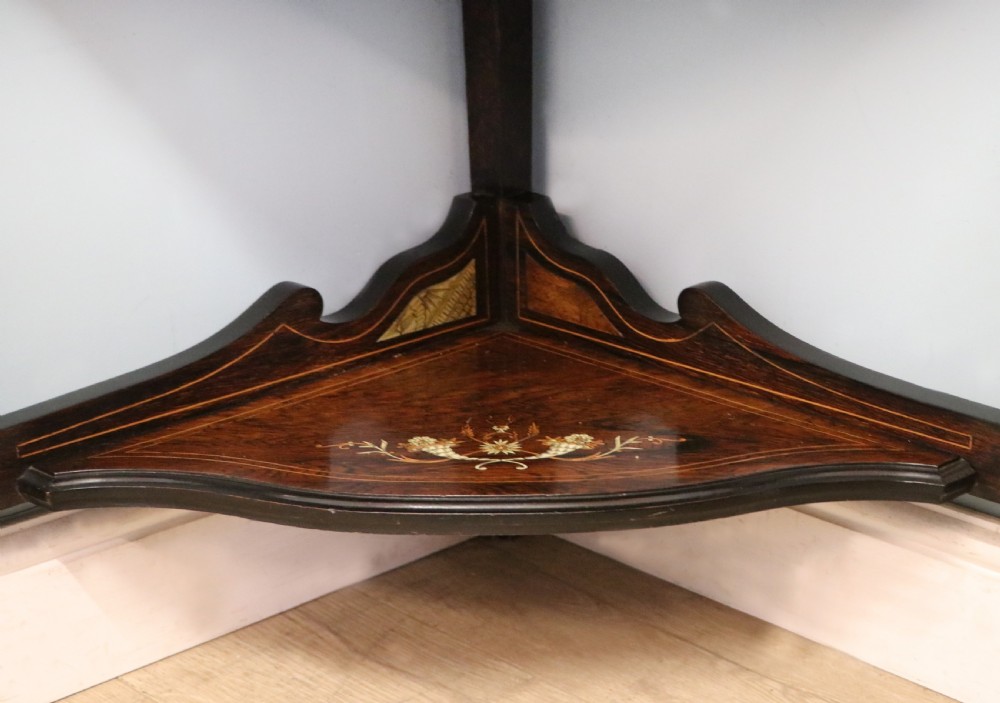 An early twentieth-century Sheraton Revival mahogany corner table featuring elaborate floral marquetry inlay, curved legs, and an undertier shelf. View XIX
