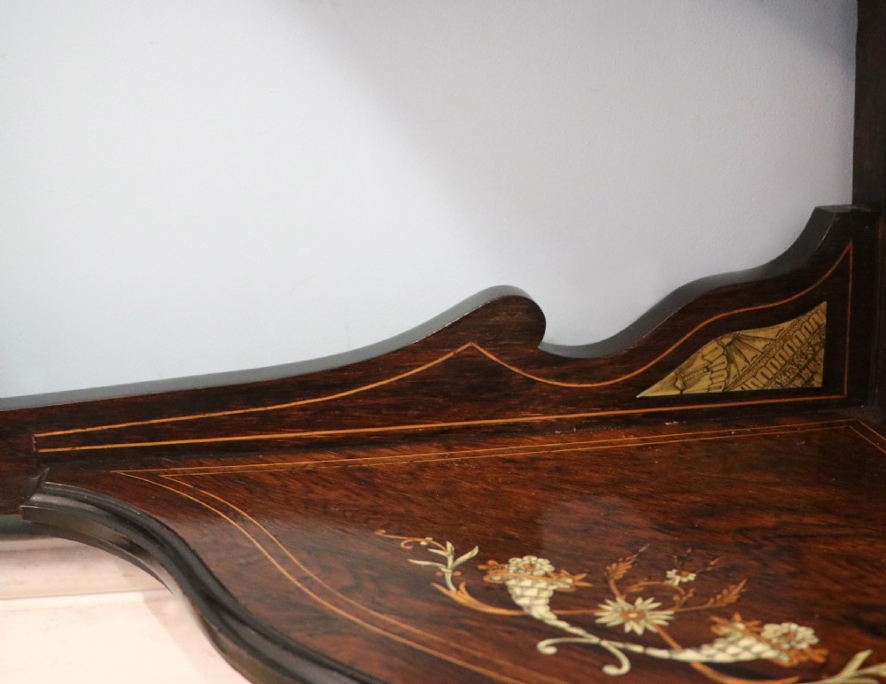 An early twentieth-century Sheraton Revival mahogany corner table featuring elaborate floral marquetry inlay, curved legs, and an undertier shelf. View XX