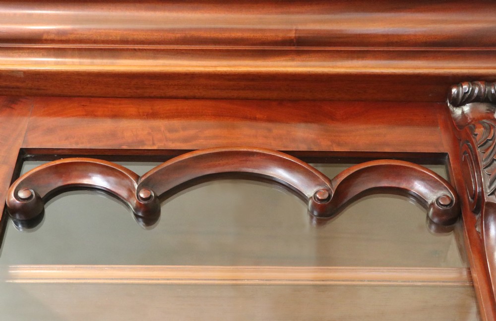 A Victorian mahogany two-height glazed bookcase featuring gilt advertising lettering on the glass doors and lower panelled doors. View XI