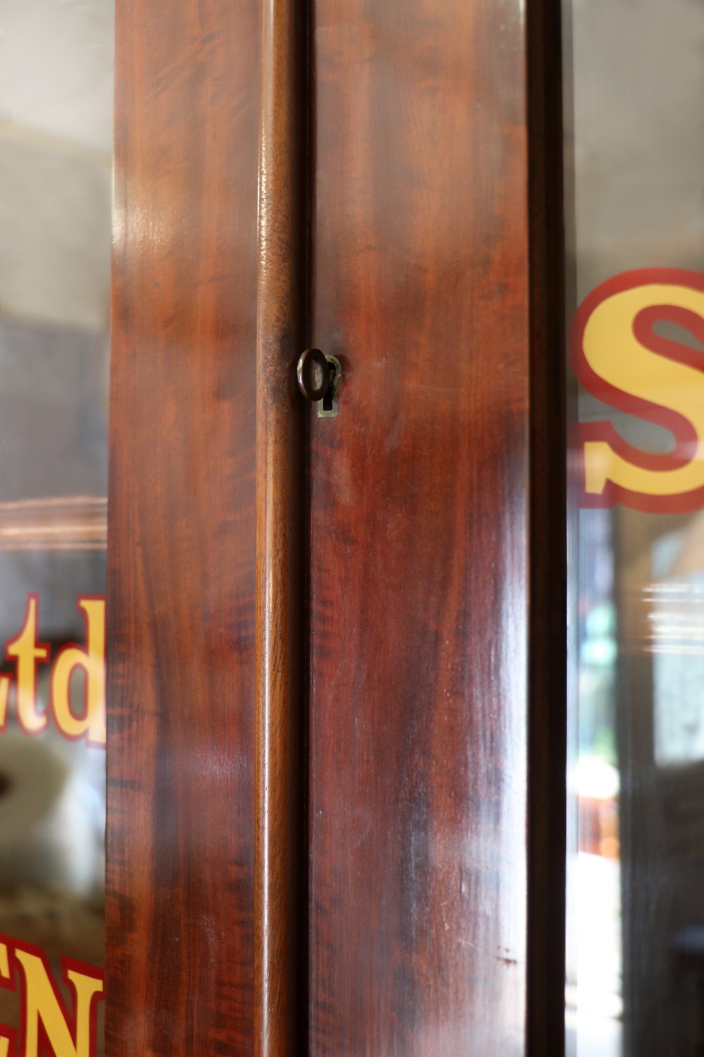 A Victorian mahogany two-height glazed bookcase featuring gilt advertising lettering on the glass doors and lower panelled doors. View XVI