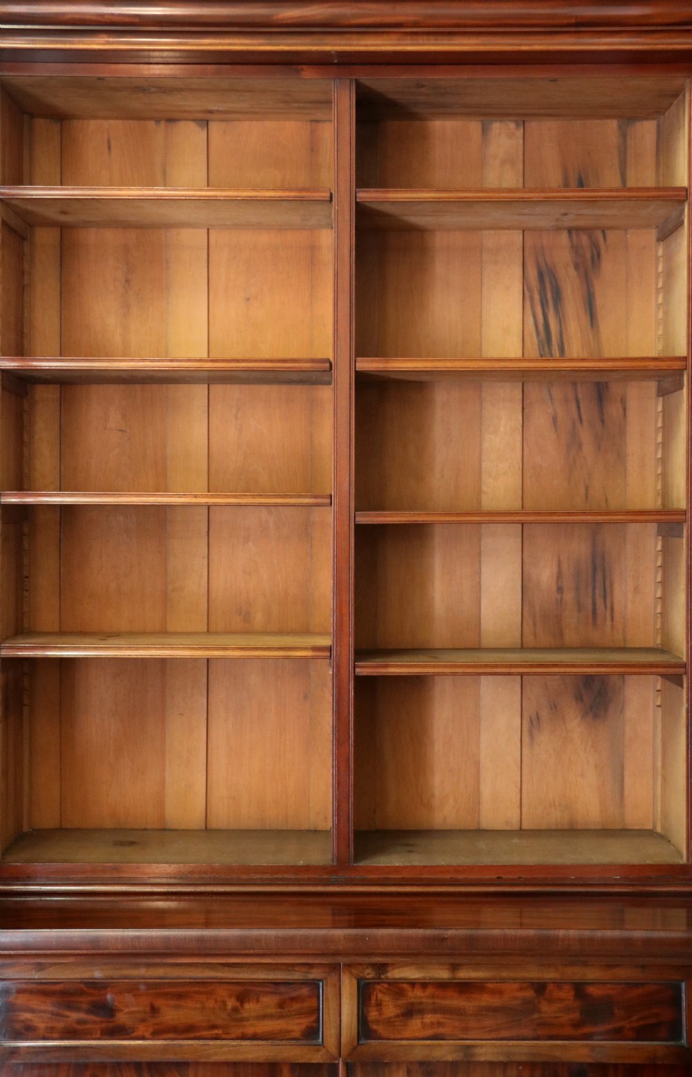 A Victorian mahogany two-height glazed bookcase featuring gilt advertising lettering on the glass doors and lower panelled doors. View XVII