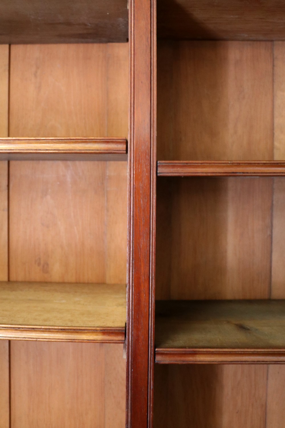 A Victorian mahogany two-height glazed bookcase featuring gilt advertising lettering on the glass doors and lower panelled doors. View XVIII