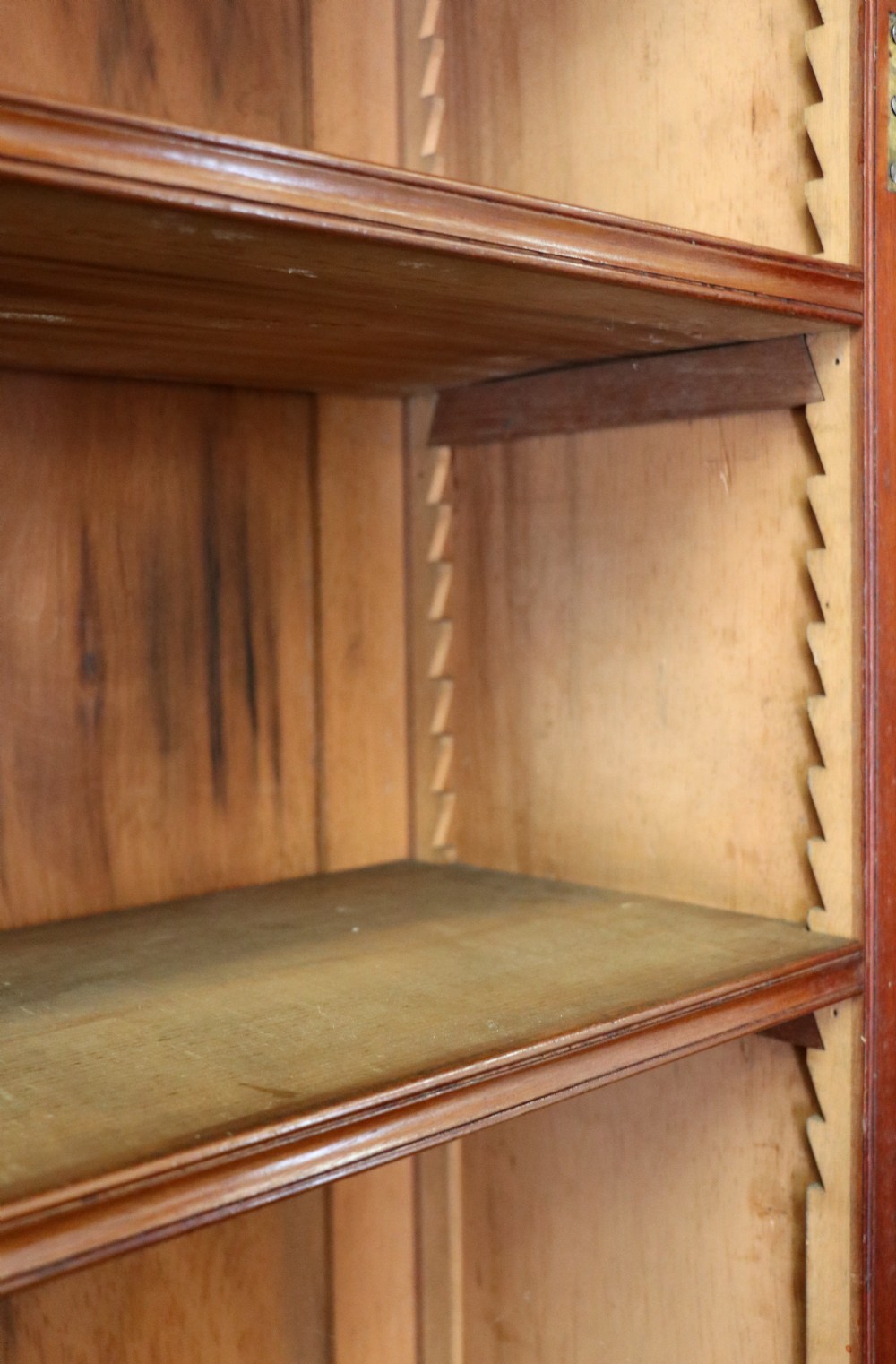 A Victorian mahogany two-height glazed bookcase featuring gilt advertising lettering on the glass doors and lower panelled doors. View XXII