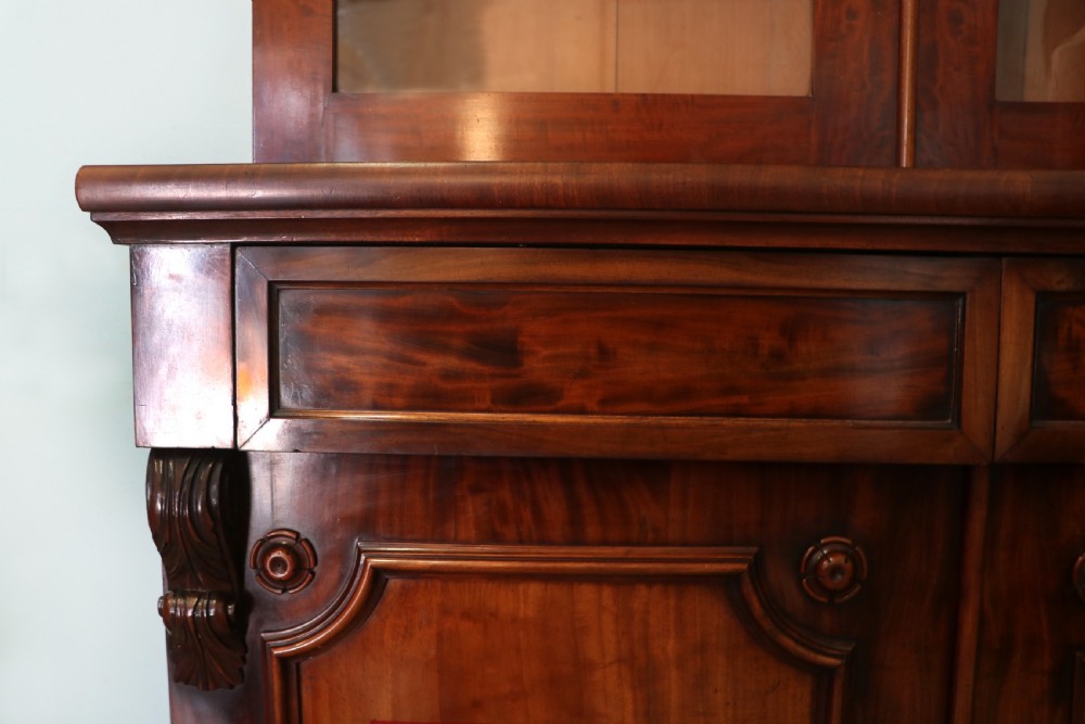 A Victorian mahogany two-height glazed bookcase featuring gilt advertising lettering on the glass doors and lower panelled doors. View XXIII