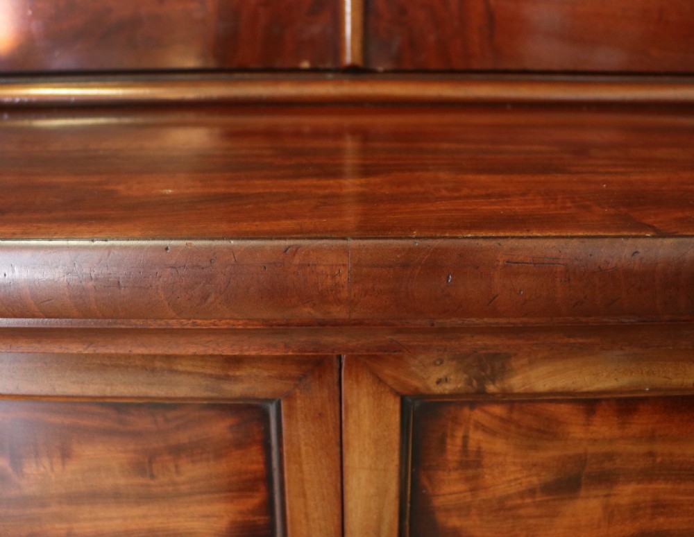 A Victorian mahogany two-height glazed bookcase featuring gilt advertising lettering on the glass doors and lower panelled doors. View XXVI