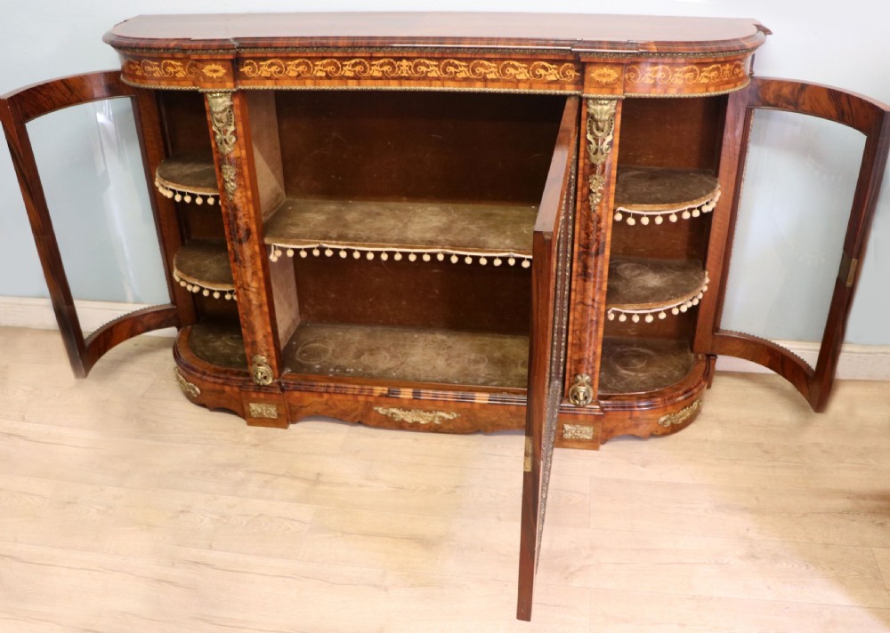 A Victorian walnut credenza featuring floral marquetry inlay, a central glazed door, two curved glass side doors, and gilt metal mounts. View III