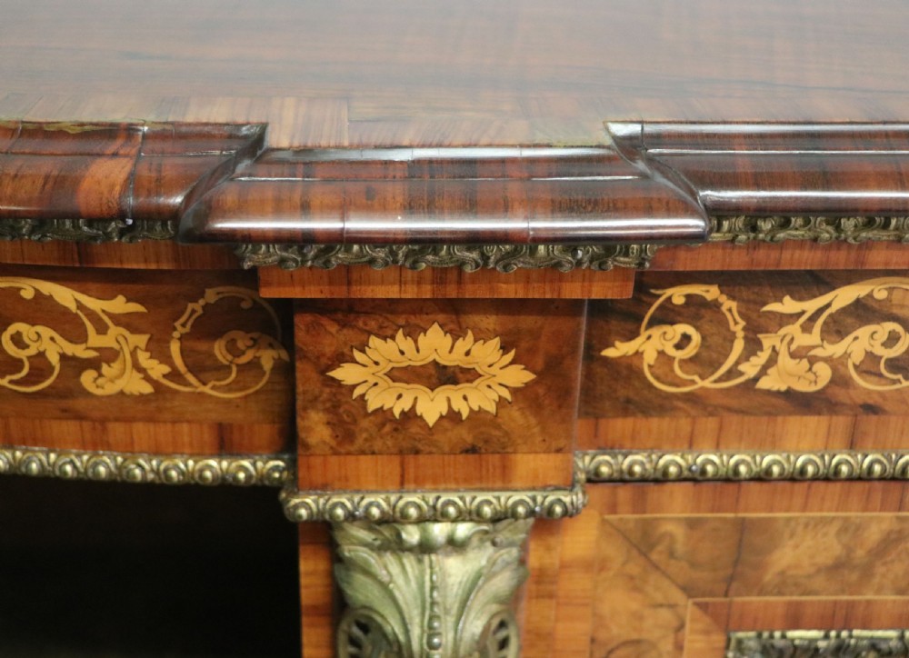 A Victorian walnut credenza featuring floral marquetry inlay, a central glazed door, two curved glass side doors, and gilt metal mounts. View XX
