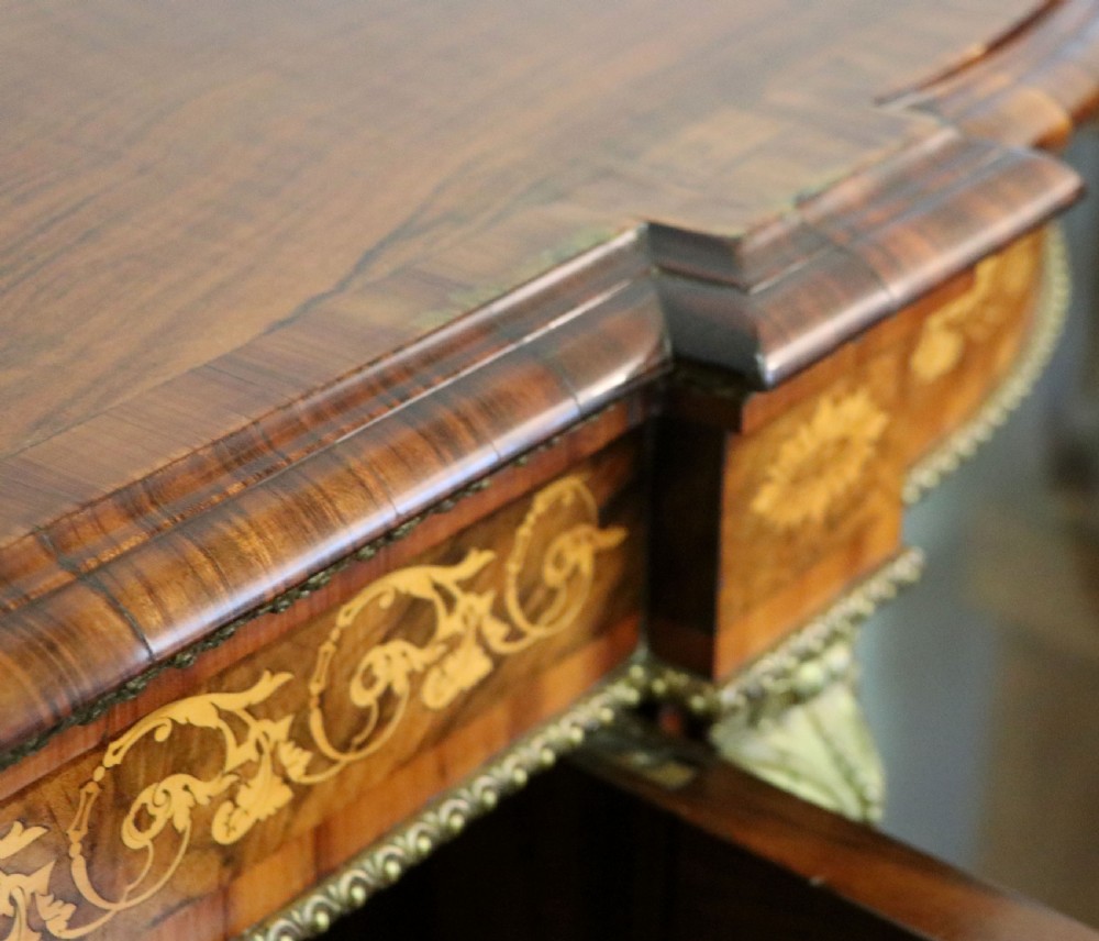A Victorian walnut credenza featuring floral marquetry inlay, a central glazed door, two curved glass side doors, and gilt metal mounts. View XXIX
