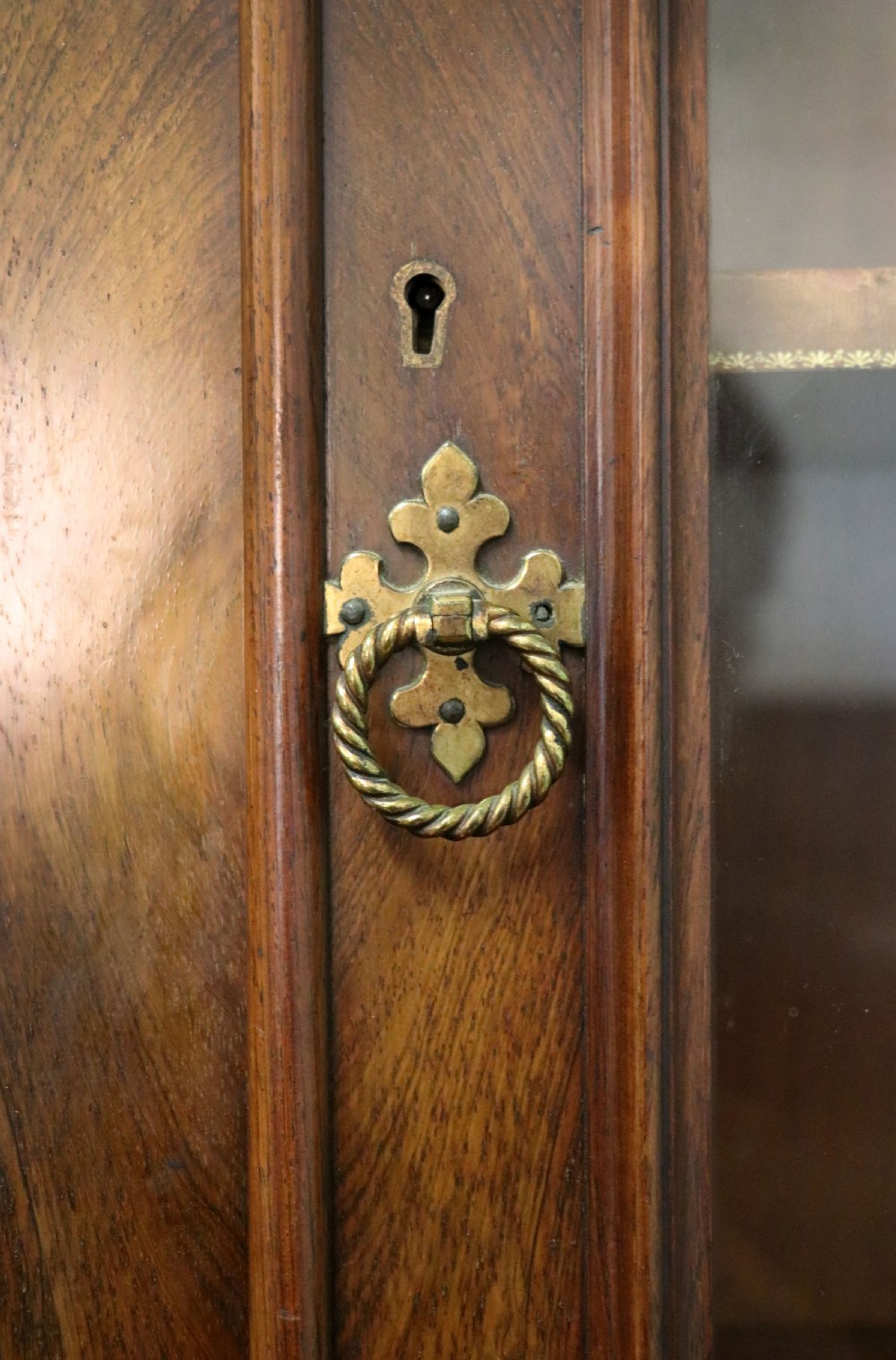 An early Victorian glazed secretaire bookcase cabinet in dark figured wood with carved arch details, a central desk drawer, and lower cupboard doors. View XXII