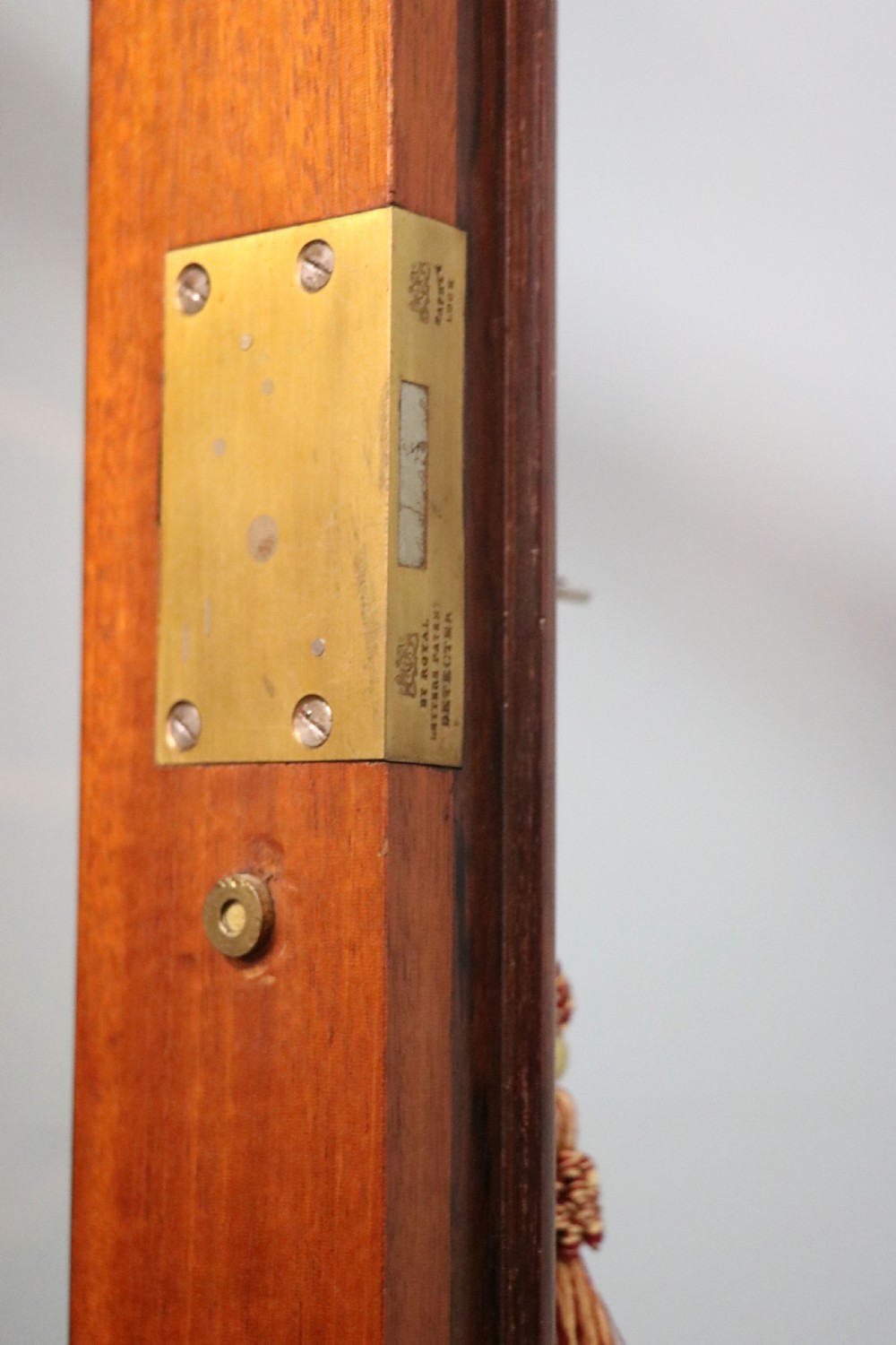 An early Victorian glazed secretaire bookcase cabinet in dark figured wood with carved arch details, a central desk drawer, and lower cupboard doors. View XXVI