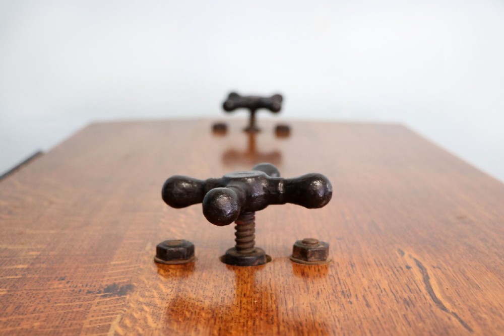 An antique Victorian cast iron mangle with a green and red painted frame, wooden wringer rollers, and a wood tabletop. View X
